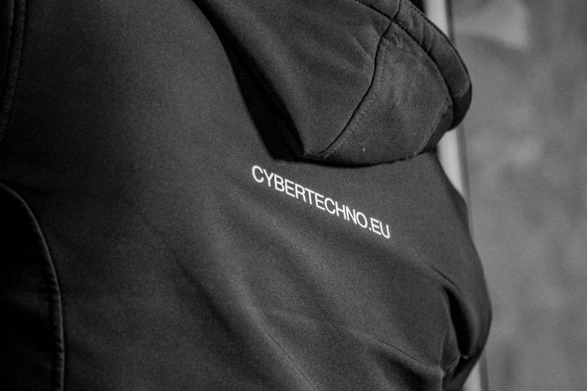 Tecnico di spalle, con giacca CyberTechno, al lavoro davanti a un armadio T-RACKS aperto