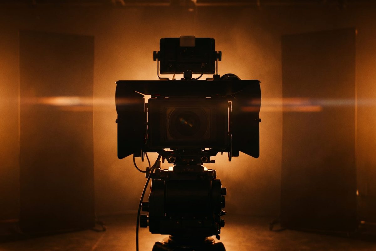 Stage of a live event filmed by a broadcast camera, with stage lighting and an audience